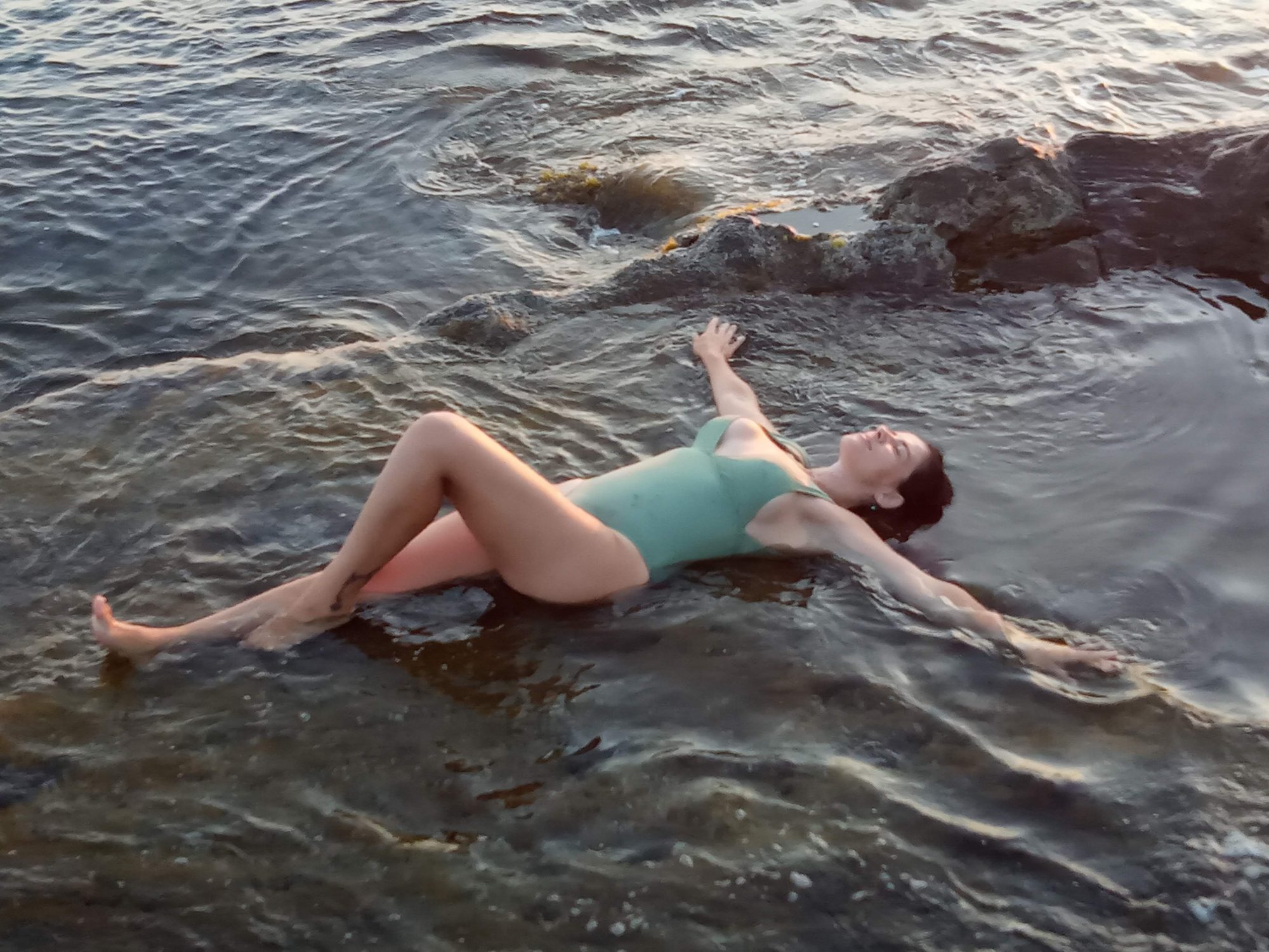 Sofia distesa nell'acqua bassa tra gli scogli